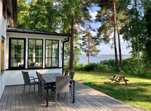 a screened in porch with a table and chairs on a deck at Flemma Gård Wing residence with lake view in Vreta Kloster