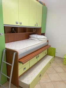 a room with two bunk beds and green cabinets at Casa Vacanze - Oliveri - Sicilia in Oliveri