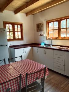 a kitchen with a table with a red and white table cloth at Cabañas Ocean Forest in El Tabo