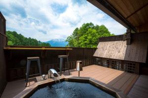 Tsutaya Tokinoyado Kazari في كيسو: حوض استحمام ساخن على سطح المنزل