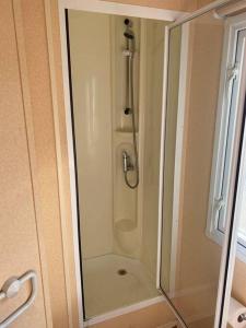 a shower with a glass door in a bathroom at Retro house in nature in Šamorín