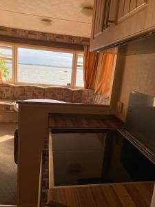 a kitchen with a view of the ocean from an rv at Retro house in nature in Šamorín