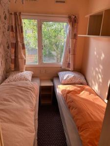 a small room with two beds and a window at Retro house in nature in Šamorín