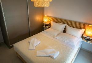 een slaapkamer met een bed met twee handdoeken erop bij ELEGANT BEACH HOUSE in Artemida +14 foto's