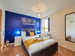 um quarto com uma cama grande e uma parede azul em Beauchamp Suite in Coventry City Centre for Contractors Professionals Tourists Relocators Students and Family em Coventry