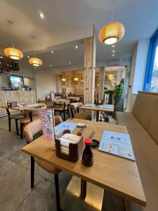 um restaurante com mesa, cadeiras e mesas em See the Sea Hideaway em The Mumbles