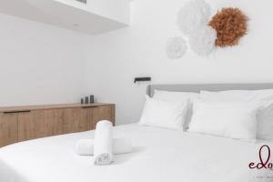 a bedroom with a white bed with white pillows at דירת 2 חדרי שינה וסלון 50 מטר מהים- By Edomlux in Eilat +11 photos