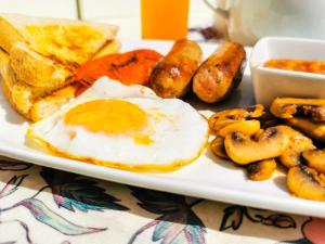 a plate of breakfast food with eggs sausage and toast at Genesis Guesthouze in Bela-Bela