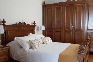a bedroom with a large bed with wooden cabinets at Arrochela apartamento in Ribeira