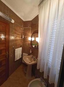 a bathroom with a sink and a shower curtain at Arrochela apartamento in Ribeira +16 photos