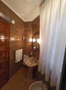 a bathroom with a sink and a shower curtain at Arrochela apartamento in Ribeira