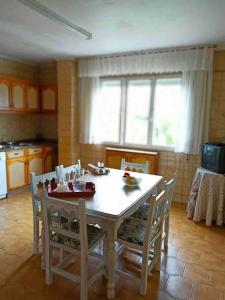 a kitchen with a table and chairs in a room at Arrochela apartamento in Ribeira