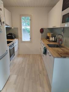 uma cozinha com electrodomésticos brancos e piso em madeira em Private room in a house w/ pool em Helsínquia
