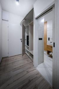 Cette chambre dispose de murs blancs et d'un couloir revêtu de parquet. dans l'établissement Zikovka, à Olomouc