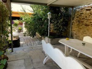 d'une terrasse avec une table et deux bancs blancs. dans l'établissement A Casa do Abuelo, à Ourense