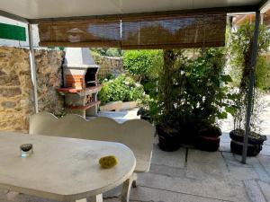 una mesa blanca y sillas en un patio con plantas en A Casa do Abuelo, en Ourense