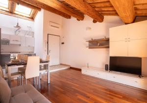 a living room with a dining table and a television at Mansarda Colombo - Car Parking in Ferrara