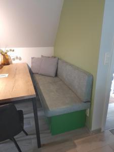a couch in the corner of a room with a table at L'Écureuil - Terrasses de Malmedy in Malmedy