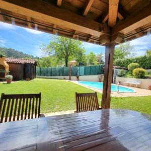 a wooden table with two chairs in a backyard at La puerta de Fredo in Arboleya