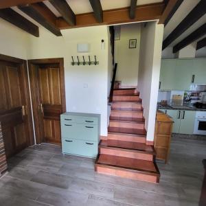 escalera en una habitación con suelo de madera y cocina en La puerta de Fredo en Arboleya