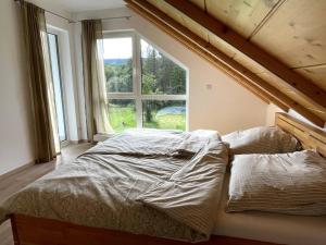 Schleusingen的住宿－Urlaub-Im-Erletal，卧室内的一张床铺,设有大窗户