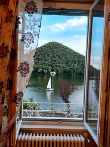 a window with a view of a sailboat in a lake at Le finestre sul lago in Piediluco