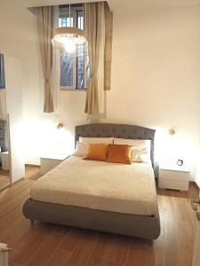 een slaapkamer met een bed en een kroonluchter bij Appartamento Aretusa di G&G in Siracusa