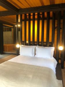 ein großes Bett mit weißen Kissen in einem Zimmer in der Unterkunft Casa Container 80 in Campos do Jordão