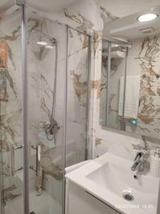 een badkamer met een douche, een wastafel en een spiegel bij Casa La Marina in Alcossebre