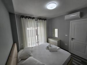 een kleine slaapkamer met een bed en een raam bij Tirana Apartment Comfort Home in Tirana