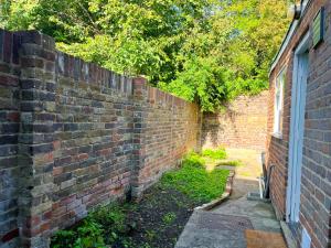 an old brick wall next to a building at Canterbury King bed house with Free Parking & Garden in Canterbury