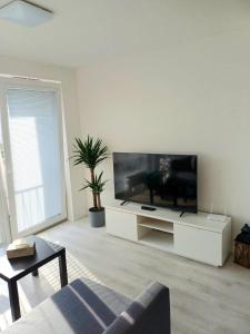 a living room with a large flat screen tv at Nový, klimatizovaný, útulný apartmán s garážou, 5 min od letiska in Bratislava