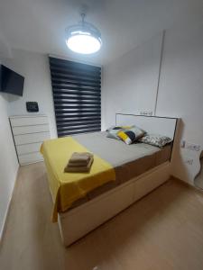 a bedroom with a large bed with a yellow blanket at Apartamento en Miami Platja - Tarragona in Miami Platja