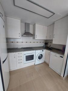 a kitchen with white cabinets and a washer and dryer at Apartamento en Miami Platja - Tarragona in Miami Platja