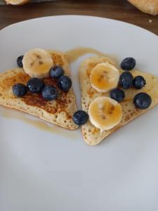 two slices of toast with blueberries and bananas on a plate at IN LUX Apartment Skopje 