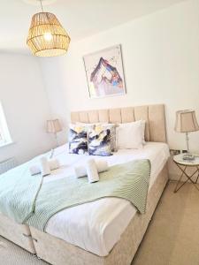 a bedroom with a large bed and two lamps at Spacious Luxury Serviced Apartment Stevenage Free Private Parking & WIFI by Stay Local Home Welcome Contractors Business Travellers Families in Stevenage
