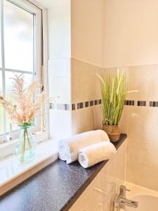 a bathroom with a sink and a window and towels at Spacious Luxury Serviced Apartment Stevenage Free Private Parking & WIFI by Stay Local Home Welcome Contractors Business Travellers Families in Stevenage