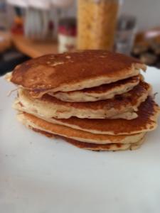 una pila de panqueques sentados en un plato blanco en IN LUX Apartment Skopje 