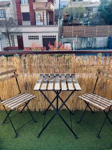 una mesa de picnic y dos sillas frente a una valla en Cocon Urbain - avec parking privé gratuit, en Toulouse