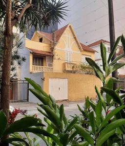 uma casa amarela com uma garagem branca em frente em Chez Zany - Copacabana no Rio de Janeiro