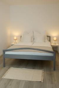 1 cama con sábanas blancas y almohadas en una habitación en Ferienwohnung Endingen am Kaiserstuhl, en Endingen am Kaiserstuhl