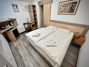 a bedroom with a large white bed with white sheets at OH Apartments & Rooms in Ljubljana