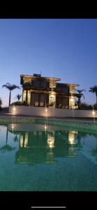 un edificio con una piscina de agua delante en Villa Palma, en Kallithea Halkidikis