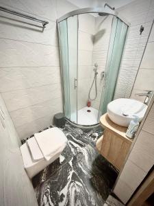 a bathroom with a glass shower and a sink at OH Apartments & Rooms in Ljubljana