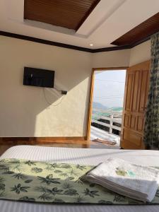 een slaapkamer met een bed en een groot raam bij Umda Hotel Galaxy in Nathia Gali