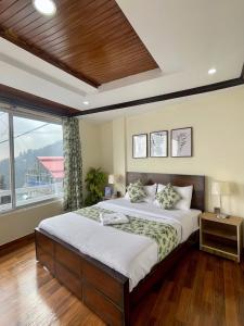 een slaapkamer met een groot bed en een groot raam bij Umda Hotel Galaxy in Nathia Gali