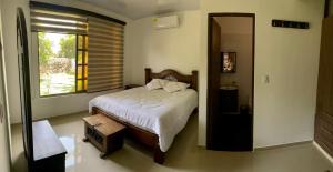 um quarto com uma cama grande e uma janela em Villa Pangara em Rivera