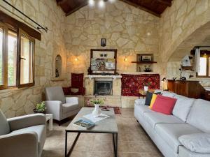 a living room with a couch and a fireplace at Villa Toula with pool Nr Armeni Crete in Makhairoí