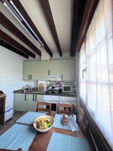 una cocina con una mesa con un tazón de plátanos. en La puerta de Fredo en Arboleya