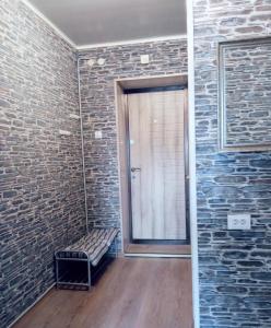 a room with a glass door and a brick wall at Vieno kambario butas Gedimino g. in Tauragė